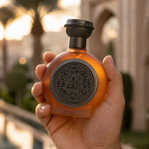 يد تحمل زجاجة عطر طيف 02 للرجال والنساء 75 مل تحت غروب ذهبي، عطور رجالية ونسائية فخمة