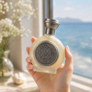 Hand holding TAIF 09 men's perfume bottle 75ml by ocean window, best fragrances for men