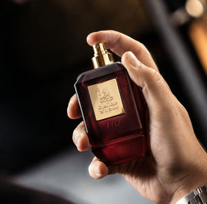 Hand holding V07 unisex perfume bottle 75ml about to spray - long lasting strawberry fragrance in dubai