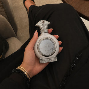 Womanin traditional uae dress holding UAE SILVER unisex perfume bottle 75ml - best unisex fragrances