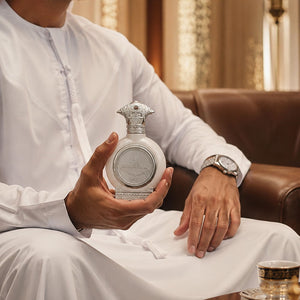 Man in traditional uae dress holding UAE SILVER unisex perfume bottle 75ml - luxury lifestyle image - best unisex fragrances