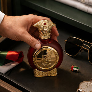 Hand lifting UAE National Day men's perfume bottle 75ml from wooden table - best national day gifts