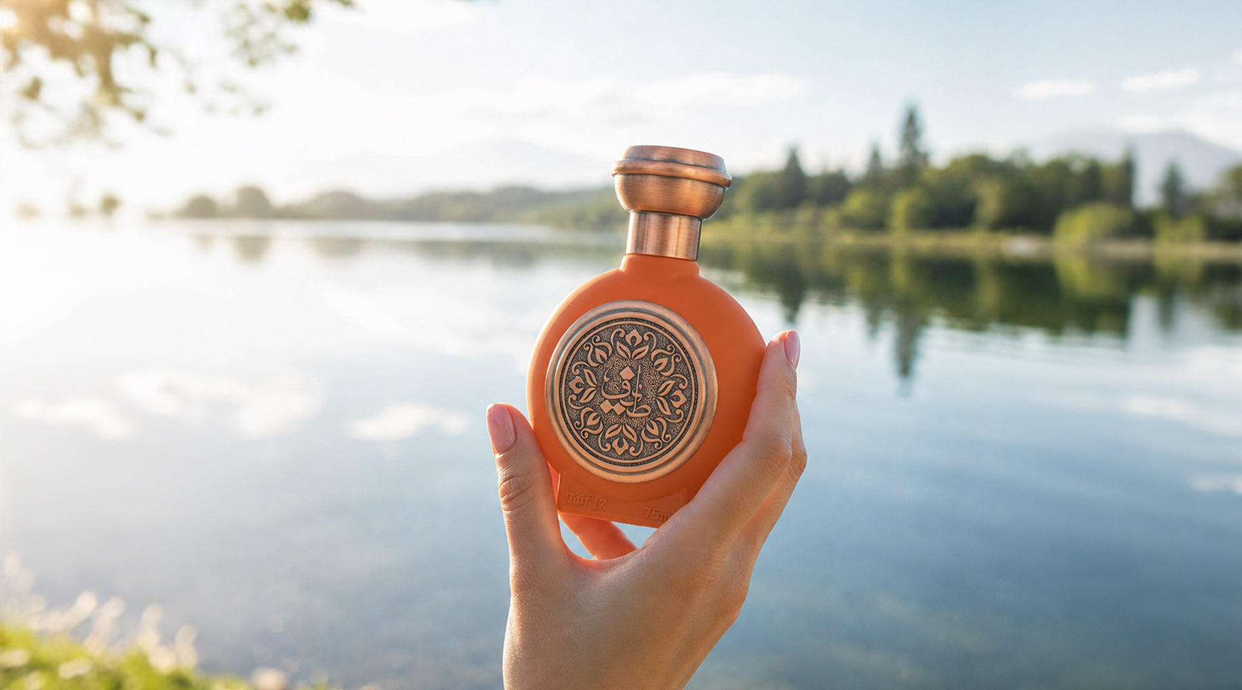 Taif Al Emarat 17 Premium Floral Patterns Bottle Surrounding Arabic Calligraphy A Calm Lake Or River Surface Reflects The Surrounding Landscape - arabic perfumes uae