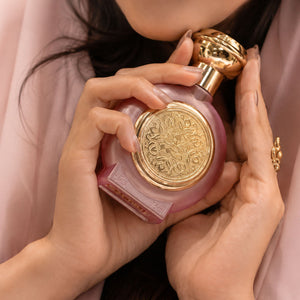 a woman holding TAIF 13 women's perfume bottle 75ml - fancy pink bottle with golden embossed taif al emarat logo - best winter fragrances