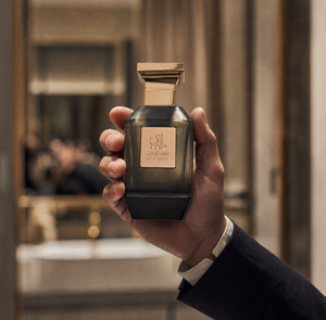 Hand holding V04 unisex perfume bottle 75ml in a luxurious interior - best black oud perfume Abu Dhabi