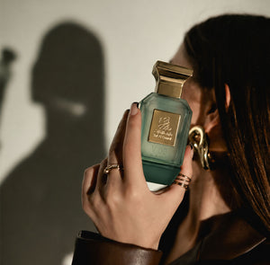 Woman holding V08 unisex perfume bottle 75ml near her face - best tobacco perfume in Abu Dhabi