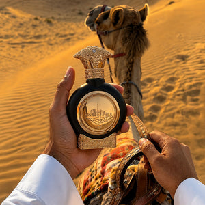 Hand holding UAE OUD men's perfume bottle 75ml before desert camel - best oud perfume for men