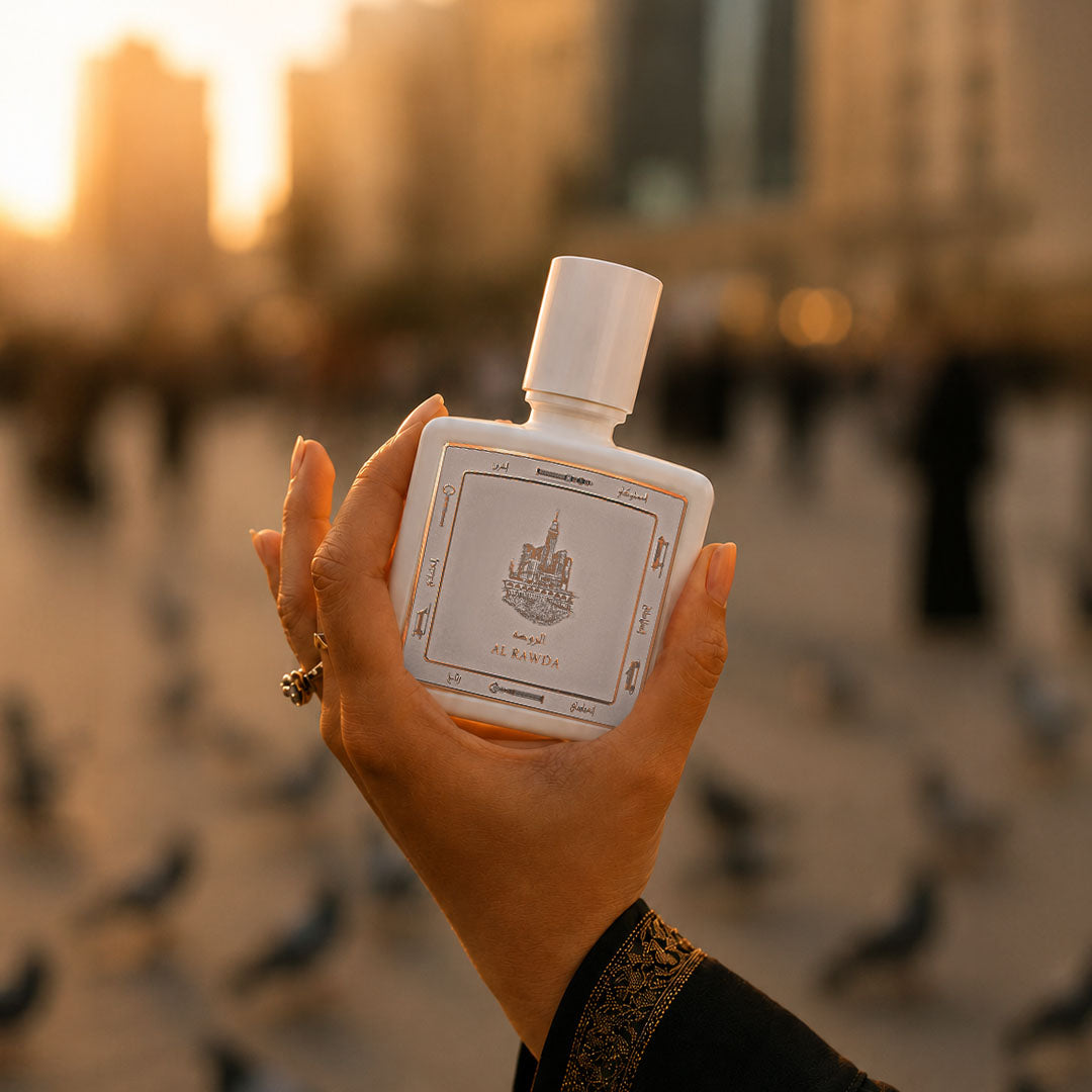 Hand holding Al Rawda perfume bottle 80ml from taif al emarat on a sunset view in the background - strong amber perfume