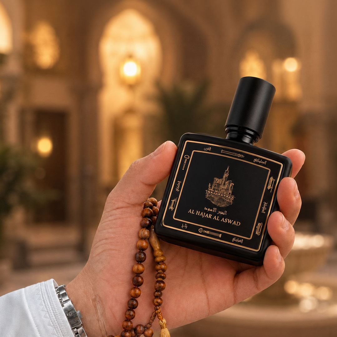 Hand holding Al Hajar Al Aswad perfume bottle 80ml from taif al emarat perfumes with prayer beads - fine oud fragrance